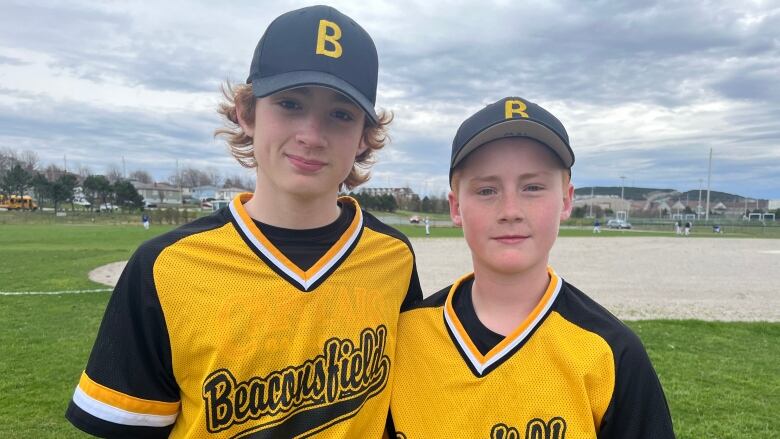 Beconsfield junior high baseball players James Moore and Will Woodford stand arm and arm on the field at Wishingwell Field in St. John's. 