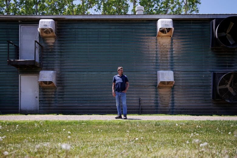 Turkey farmer Mark Reusser stands in front of one of his barns. 