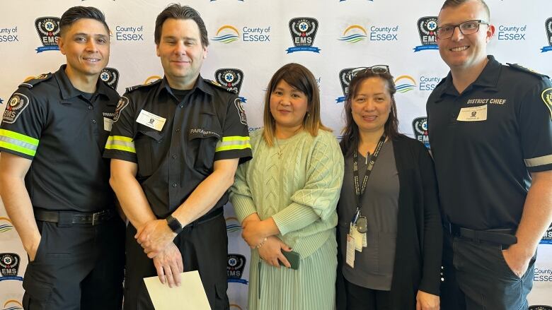 A woman pictured with paramedics in uniform. 