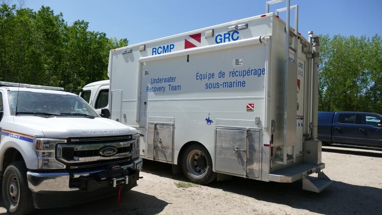 An RCMP Underwater Recovery Team vehicle is pictured next to a police truck.