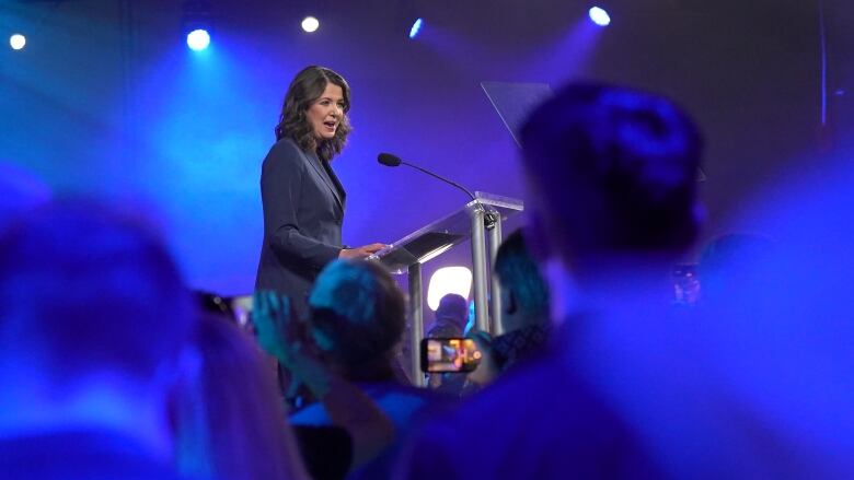 A woman stands at a podium