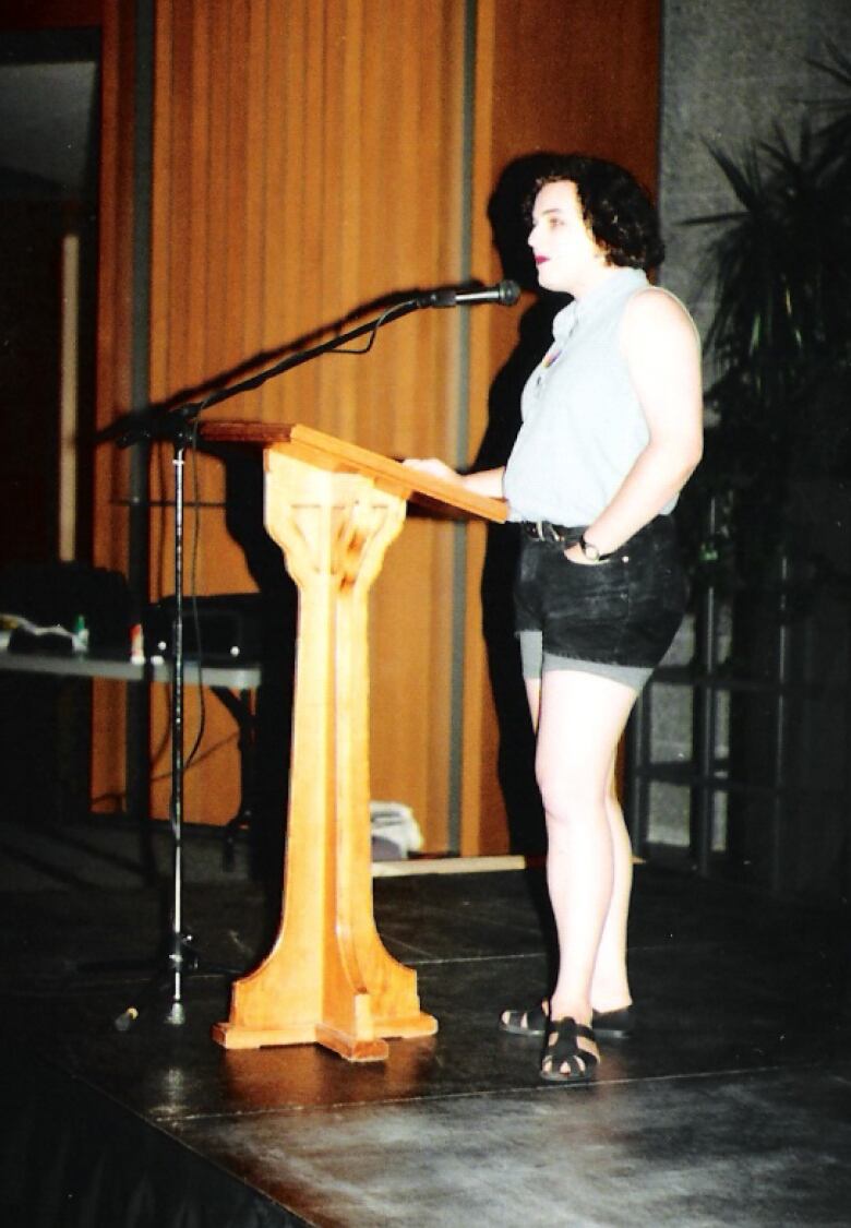 Cait Glasson standing at a microphone at the first ever Pride in the region in 1995.