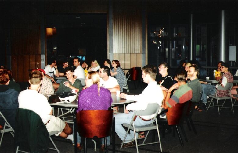 Several people sitting at tables at the first Pride in Waterloo Region in 1995.