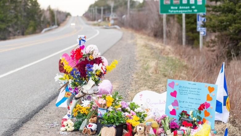 Flowers stuffed animals and homemade signs are seen along a Nova Scotia highway.