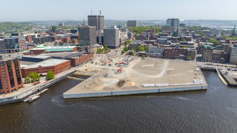 An aerial shot of a city's waterfront with an active construction site. 