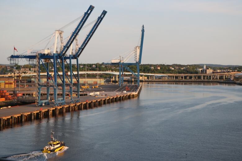 A piloat boat makes it way back home through the Port of Saint John past two giant blue gantry cranes. 