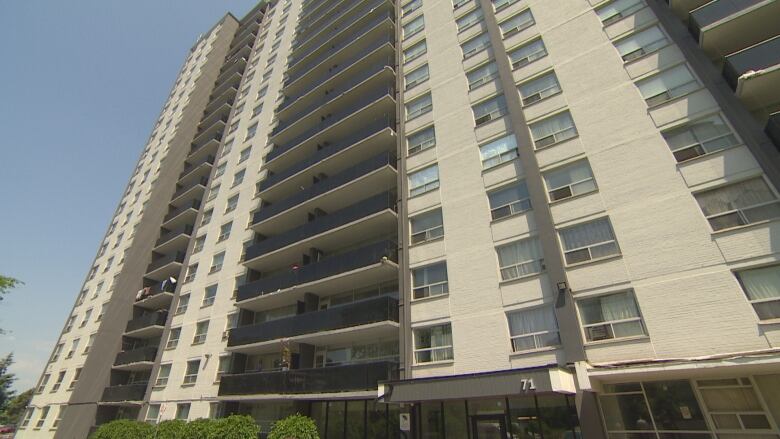 A photo of an older apartment building panned upward. 