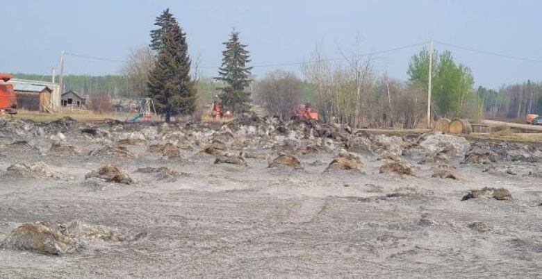 Wide shot of farmland with damaged hay bales.