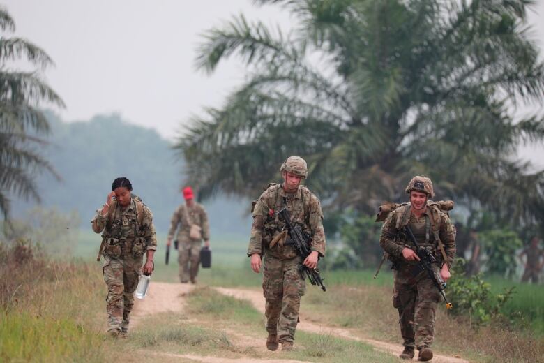 Soldiers walk in jungle