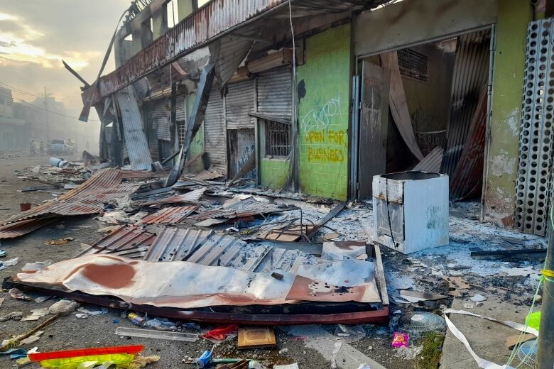 Wreckage in front of a burned out storefront 