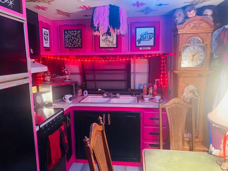 A trailer kitchen painted in bright pinks and black.