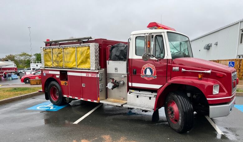 A fire truck parked outside in the rain.