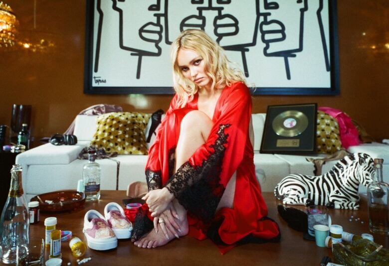 A woman sits on the floor in front of a couch.