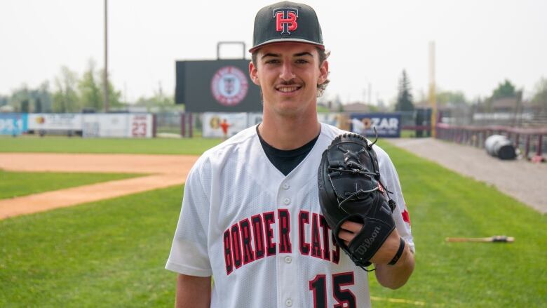 A young man with a baseball glove wearing a Border Cats jersey.