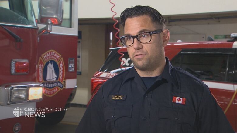 A man in a fireman's uniform speaks to the camera