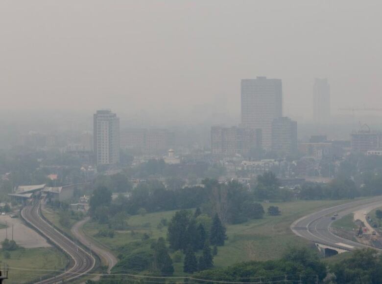 A view of some highrises on the edge of a city's downtown and wildfire smoke obscuring the view beyond it.