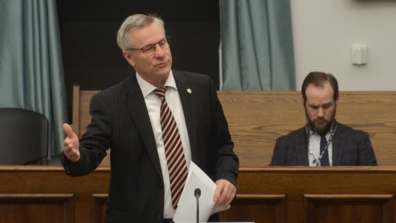 A man in a suit stands and speaks in the P.E.I. legislature.