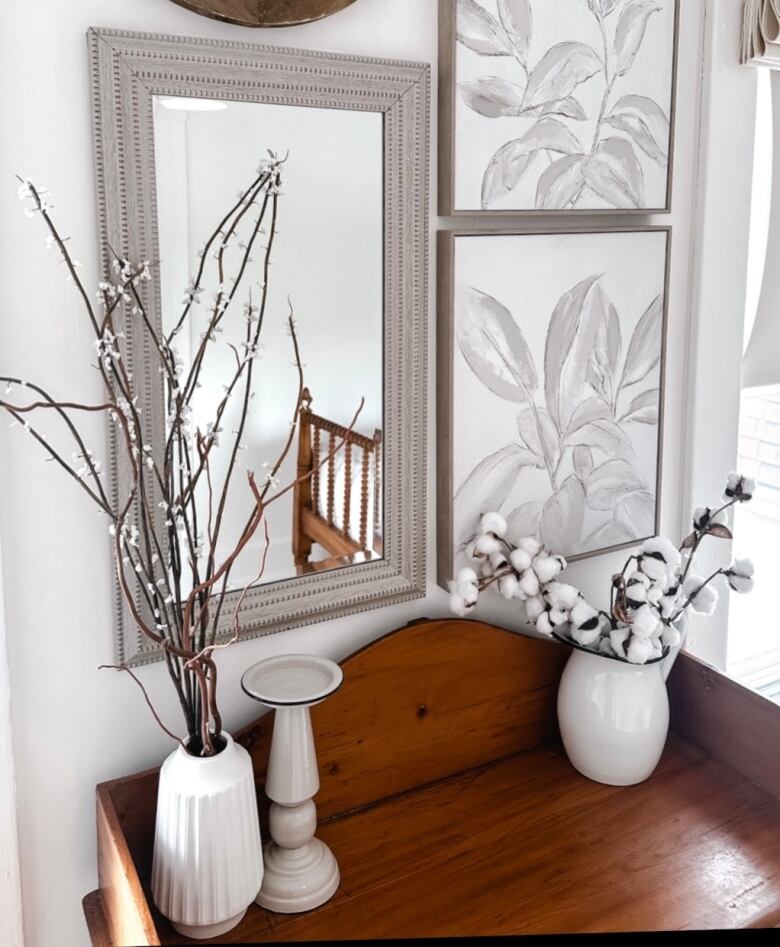 Mirror hangs above a wooden dresser. 