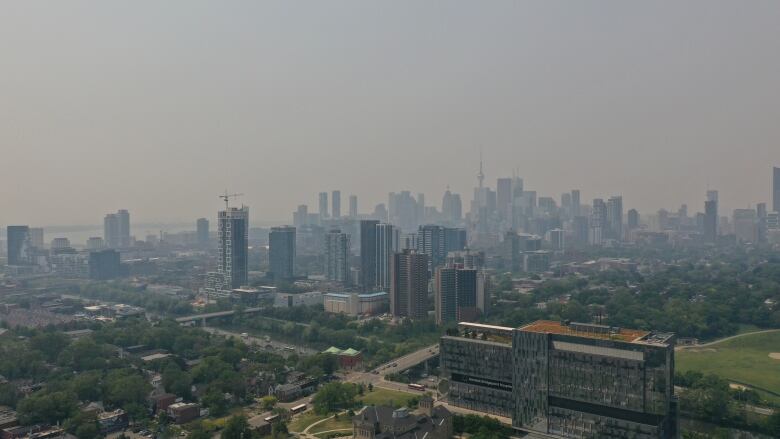 Aerial (drone) of City of Toronto covered in a thick blanket of Haze, cause by wildfire smoke. Shot from Riverdale Park