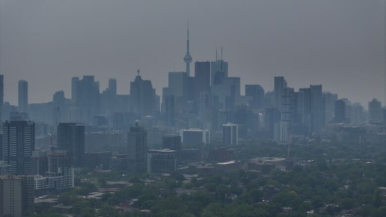 Aerial (drone) of City of Toronto covered in a thick blanket of Haze, cause by wildfire smoke. Shot from Riverdale Park