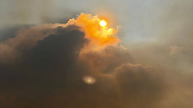 Orange sun with clouds around it