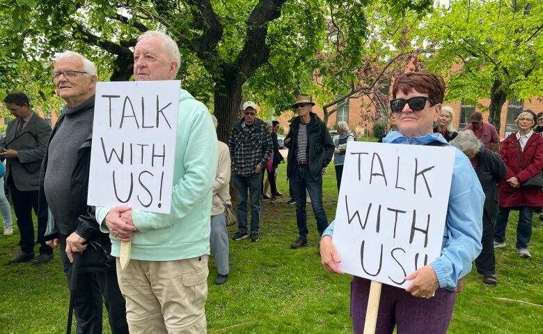 Two protestors stand on grass holding 