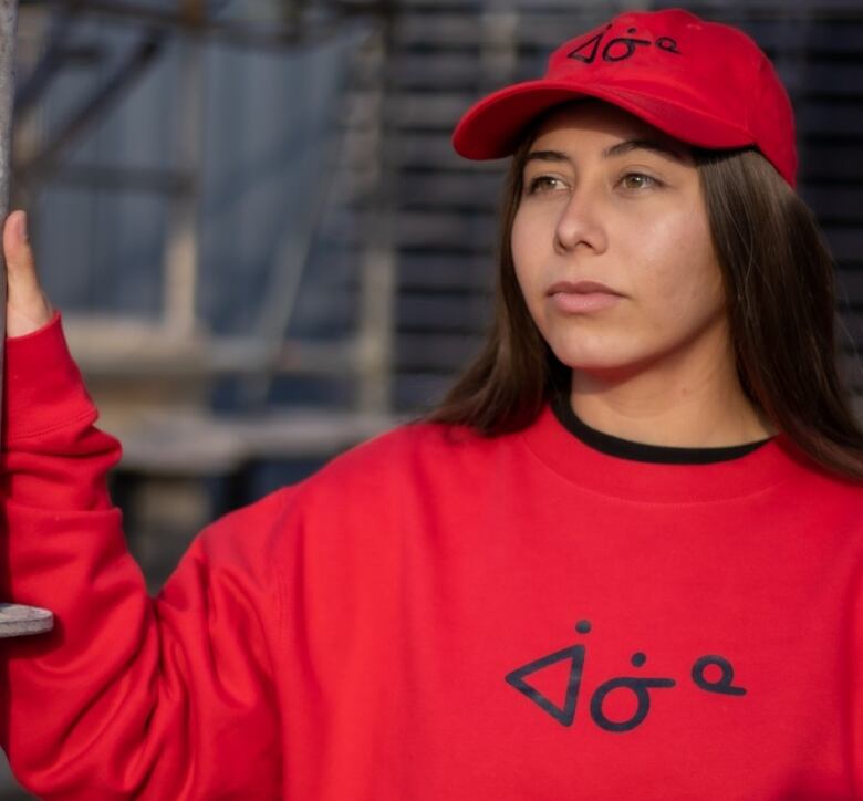 Woman wearing red sweatshirt and hat.