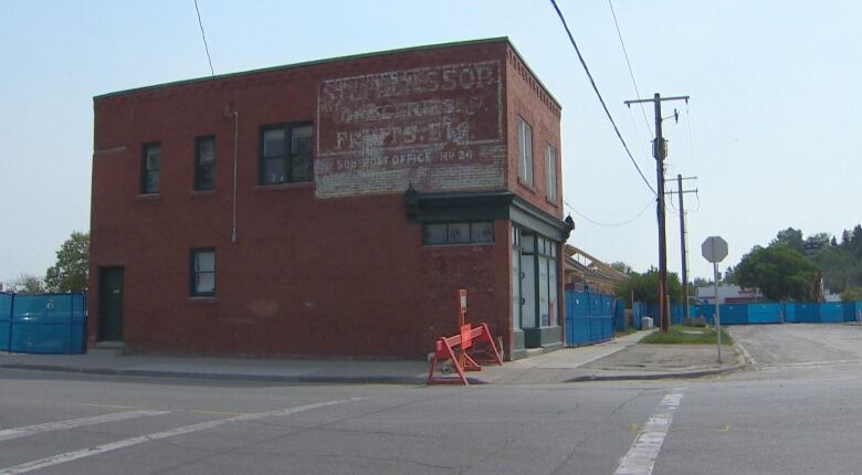 A red brick building on a street corner. 