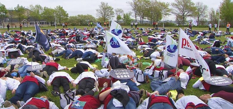 Nurses lay on the ground at Confederation Landing Park in Charlottetown.