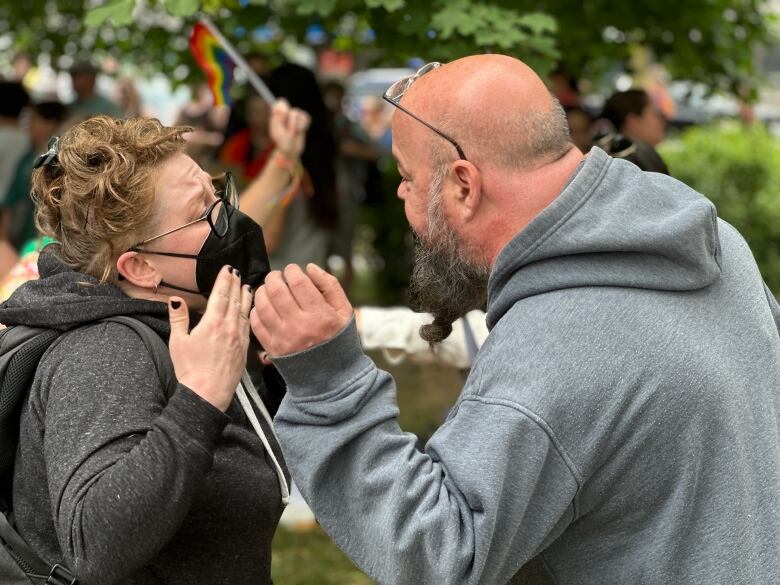 An activist in favour of drag queen story time, left, face to face with a protester.