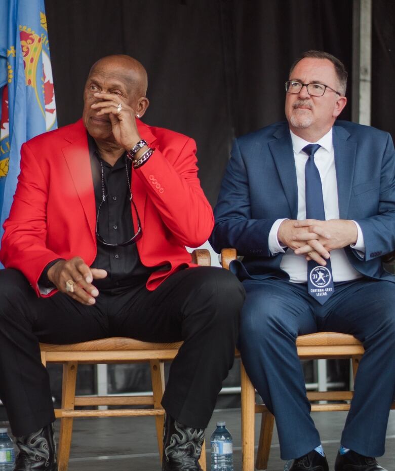 Baseball Hall of famer Fergie Jenkins wipes away a tear as he is honoured during a ceremony in his hometown of Chatham, Ont. A statue in is honour was unveiled out front of the Chatham-Kent Civic Centre. Mayor Darrin Canniff sits next to Jenkins. 