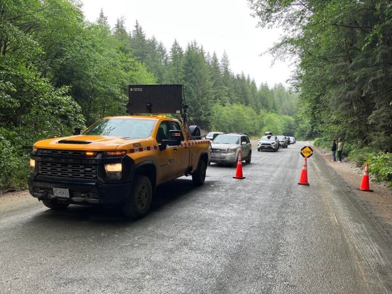 A pilot vehicle leads a convoy along a detour on western Vancouver Island on Saturday June 10, 2023.