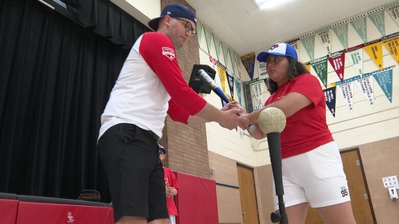 Teacher Paul Cowan, at Glenwood Public School, guides student Amelia Felix through the fundamentals of hitting a baseball off a tee. 