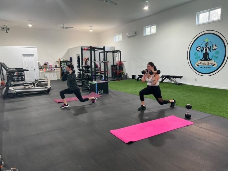 Two women working out in a gym studio. 