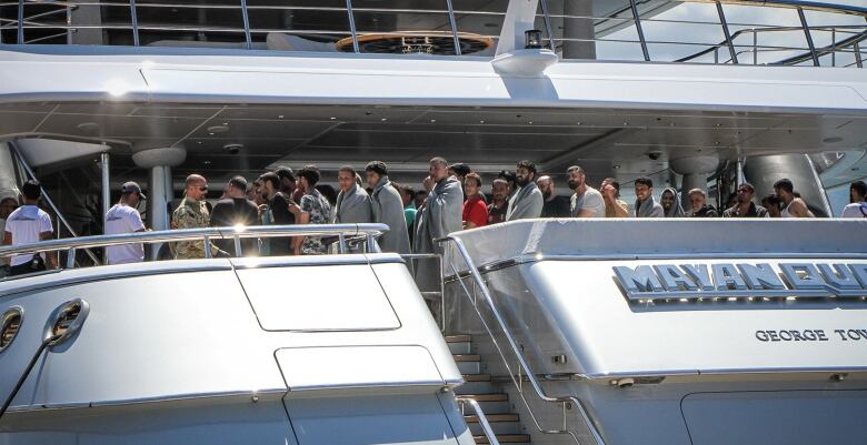 Migrants lined up on a ship after being rescued from a fishing boat that capsized off the southern coast of Greece.