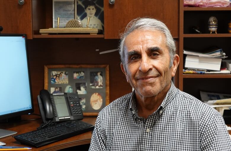 An expert sits at his office desk.