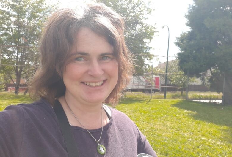 A portrait of a white woman with brown, shoulder-length hair looking into the camera.