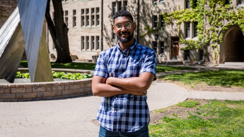 A photo of a young man in front of a university residence.