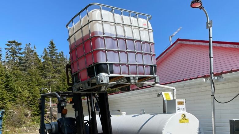 a container of fuel next to a building.