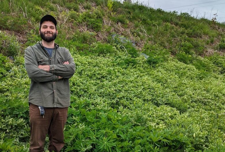 Chase Guindon standing on a hillside covered in plants.