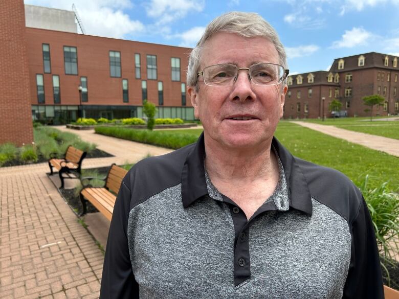 Bob Gray stands at a courtyard at UPEI.