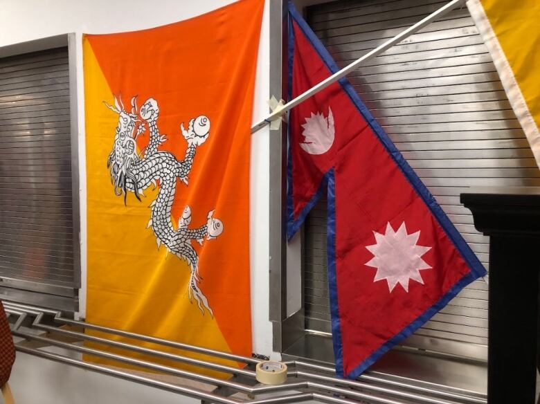 The flags of Bhutan and Nepal hanging on a wall