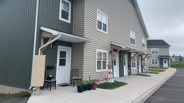 The front of a two level apartment is seen, featuring 4 front doors.