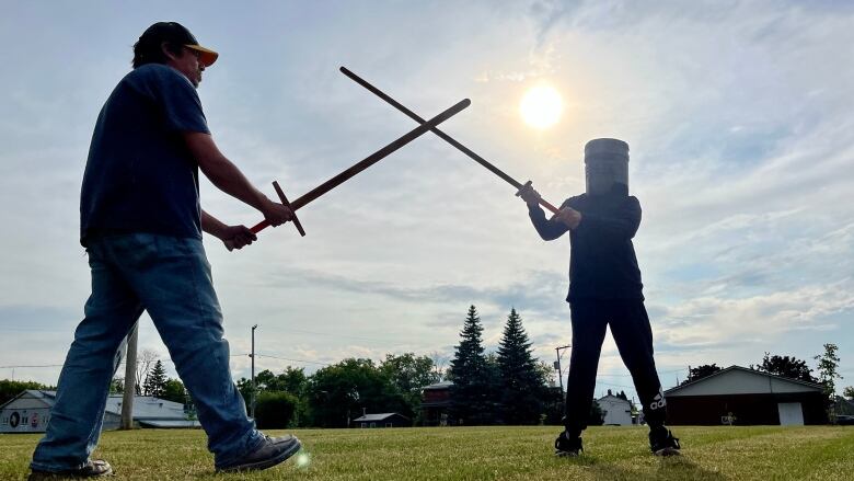 Tekaient:ton Deer (right) sparring with his dad Brennen Deer during a beginner longsword fencing class in Kahnaw:ke. 