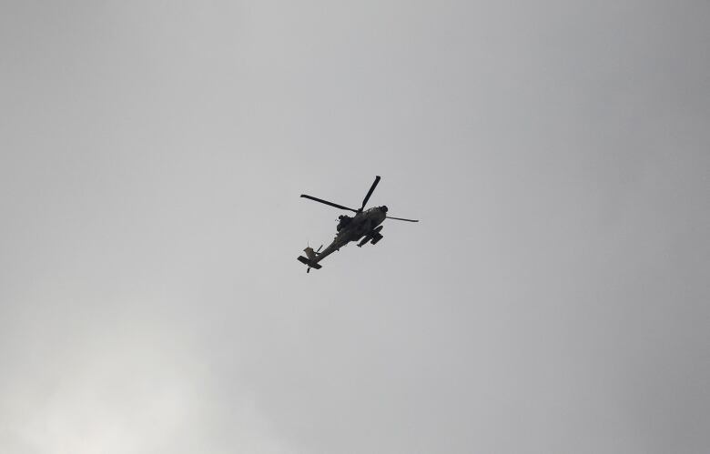 A helicopter is seen flying above.