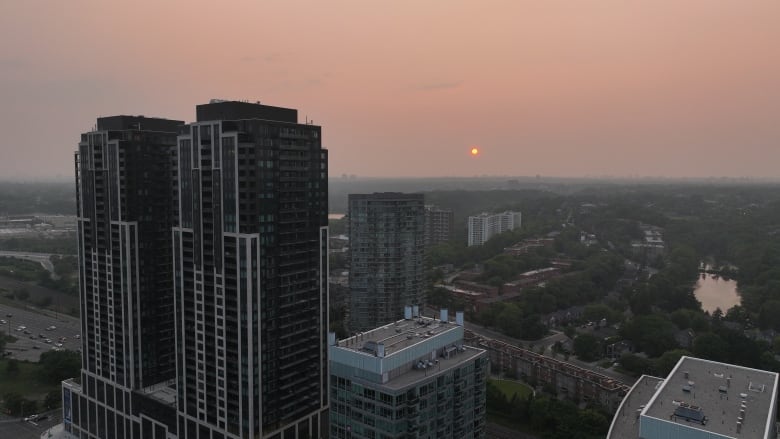 An orange sun appears along Lake Ontario