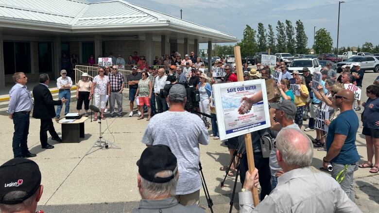 About 100 people attend a news conference outside a council building