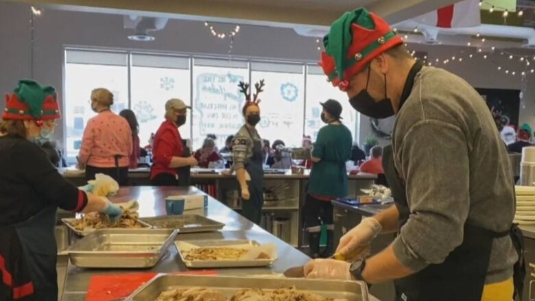 A person dressed like an elf prepares food.