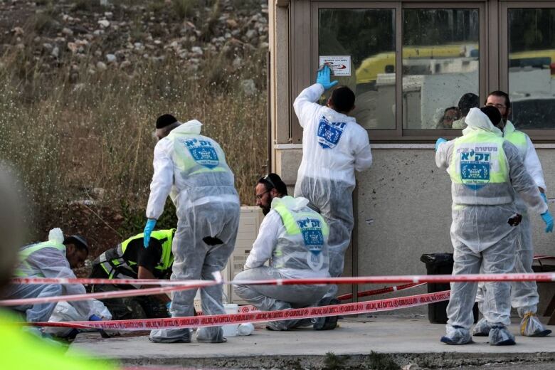 Forensics experts work at the scene of a shooting.