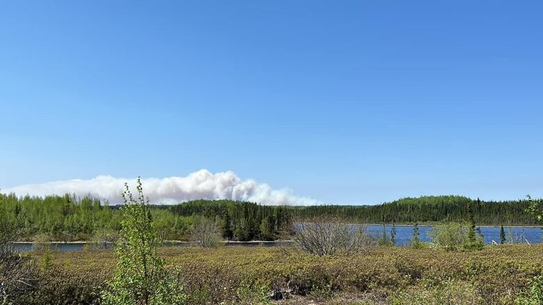 A lake image with a fire burning in the distance.